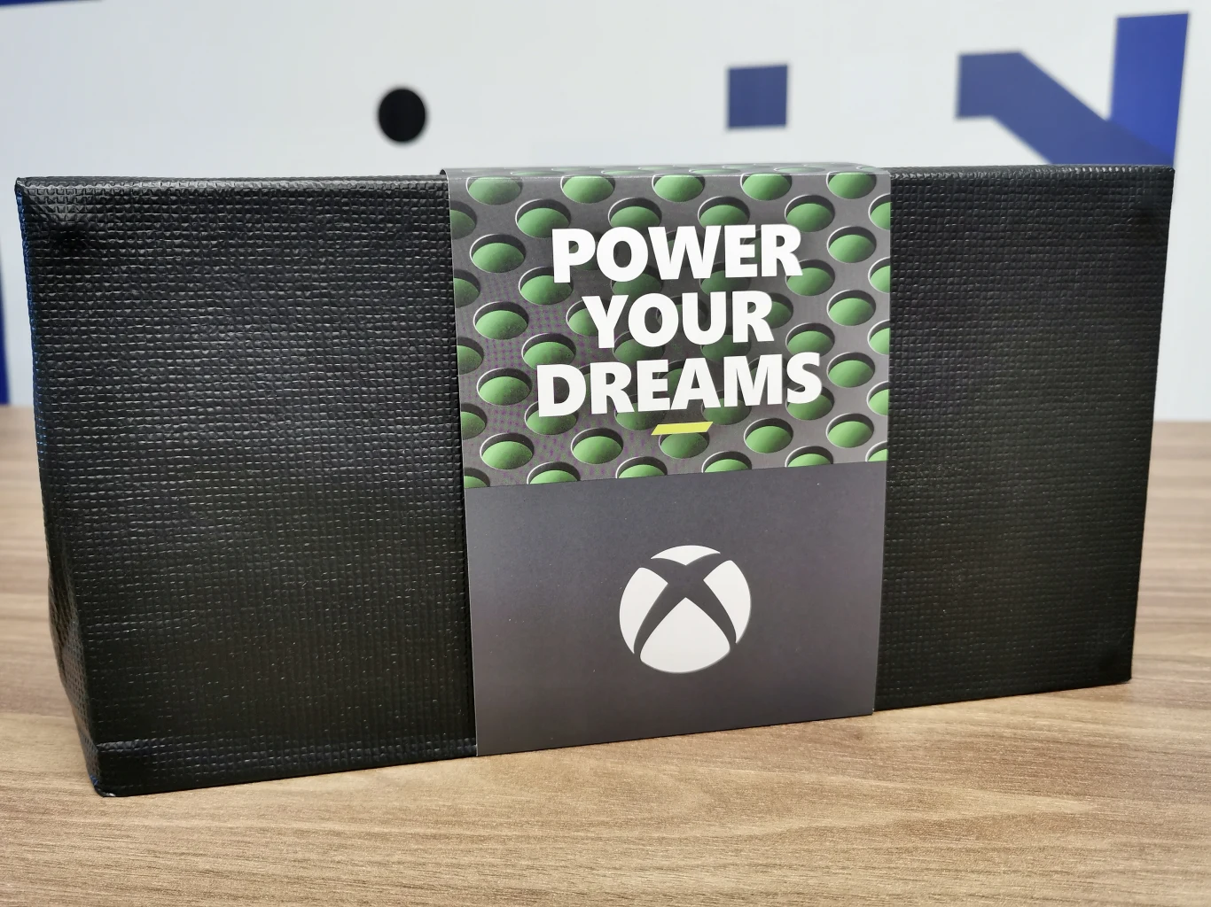 Po uchyleniu wieka pudełka oczom ukazuje się niewielkie "zawiniątko" okryte papierą szarfą z hasłem "Power Your Dreams". 