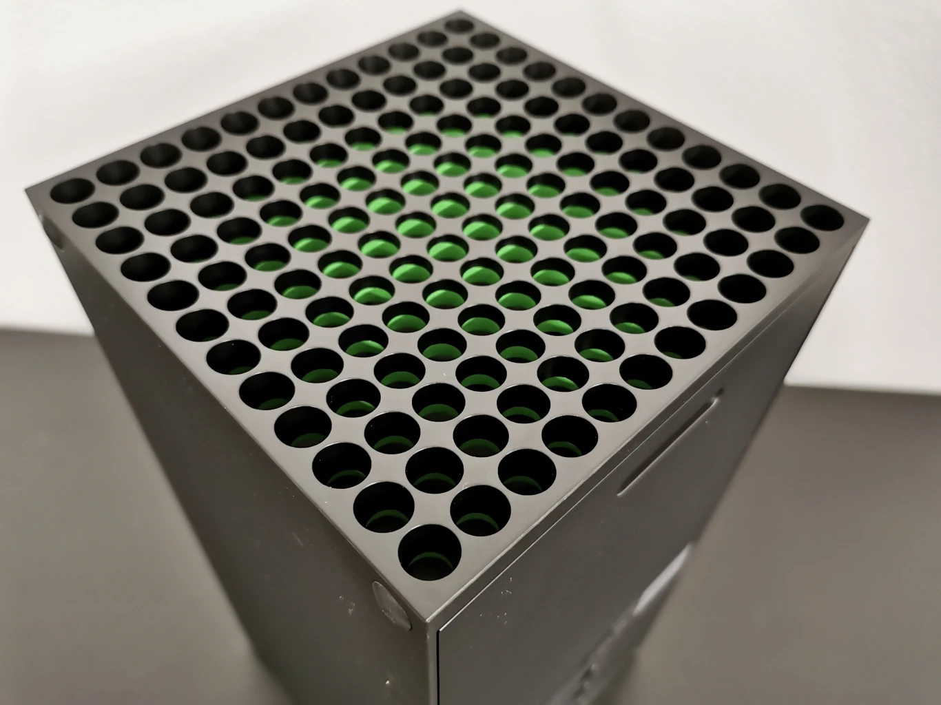 W górnej części konsoli znalazły się otwory służące do odprowadzania ciepła, a pod nimi solidny wentylator. Całość zdobi zielona poświata z efektem 3D.