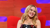 Kylie Minogue to australijska wokalistka i aktorka, która karierę rozpoczynała w kultowym serialu „Sąsiedzi”. Grała tam ponad dwa lata, zdobywając rzesze fanów.

Na zdjęciu: Kylie w programie Grahama Nortona, listopad 2020