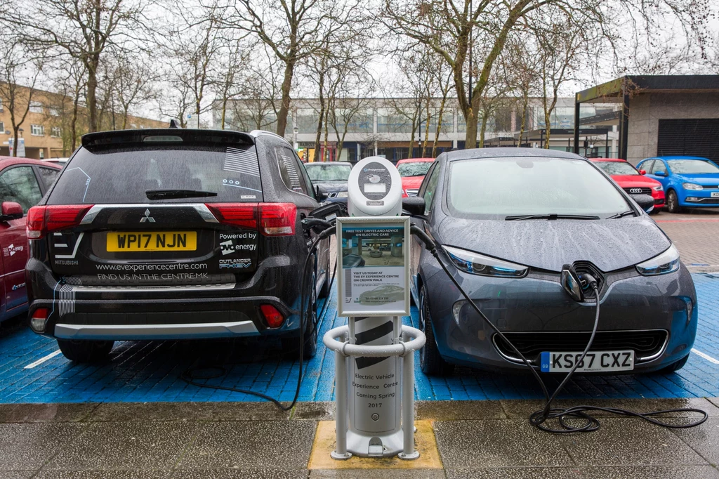 Dwa elektryki? Nic z tego - auto po lewej, chociaż ładuje się z gniazdka, to hybryda plug-in, w której silnik benzynowy głównie pełni funkcję generatora prądu. Ono też będzie zakazane w Wielkiej Brytanii.