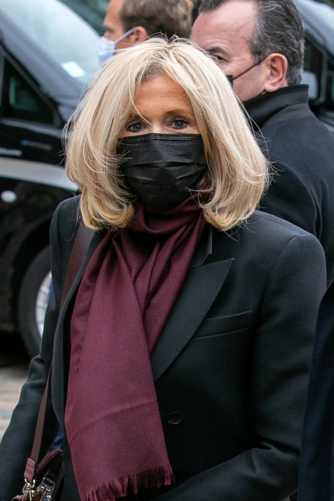 Brigitte Macron w czarnym płaszczu przełamanym  delikatnym szalem 