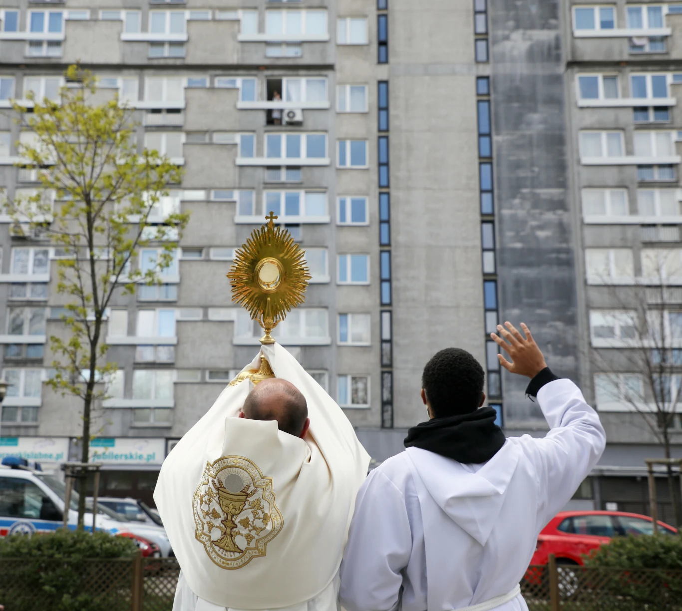 Warszawa, 19.04.2020. Niedziela Miłosierdzia Bożego. Proboszcz parafii św. Antoniego z Padwy niesie monstrancję między blokami przy ul. Senatorskiej. Procesja z wiernymi nie odbyła się z powodu epidemii