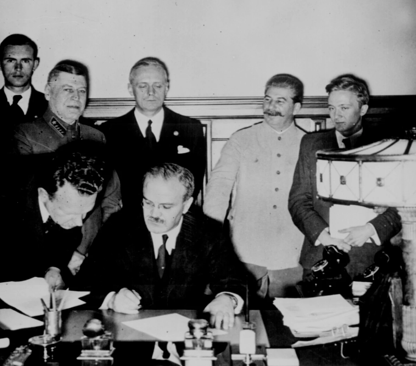 Wiaczesław Mołotow podpisuje pakt niemiecko-radziecki. W tle zadowolony Stalin Wiaczesław Mołotow podpisuje pakt niemiecko-radziecki. W tle zadowolony Stalin