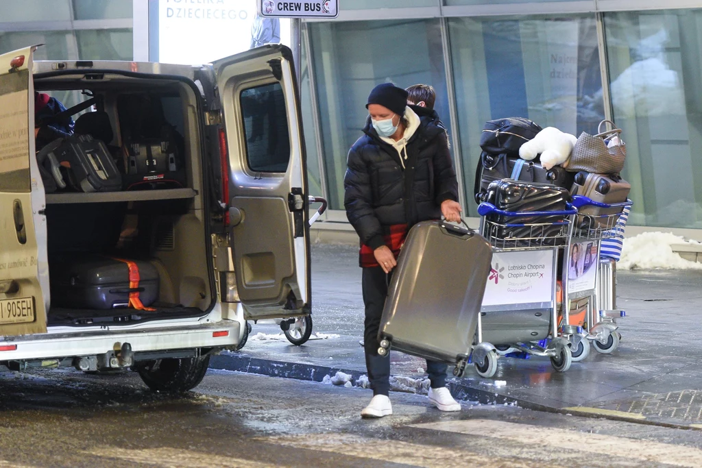 Radosław Majdan pakujący walizki z podróży do taksówki