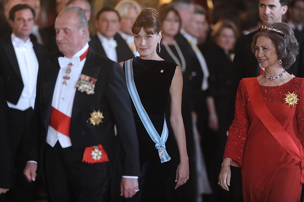 Carla Bruni Modelka i piosenkarka Carla Bruni wywołała sensację, gdy wyszła za mąż za prezydenta Francji – Nicolasa Sakroziego w 2008 roku w Pałacu Elizejskim w Paryżu. Pierwszy raz w historii Republiki Francuskiej głowa państwa wzięła ślub podczas sprawowania urzędu. Co więcej Bruni była młodsza od ukochanego o 13 lat. Francuzi nie byli zachwyceni ani różnicą wieku między małżonkami, ani eksponowaniem życia prywatnego przez prezydenta. Nie można jednak nie zgodzić się z faktem, że Carla z klasą prezentowała kraj na ważnych wydarzeniach. Podczas wizyty w Hiszpanii para prezydencka wzięła udział w królewskiej ceremonii. Carla zachwyciła gości prostą, ale efektywną kreacją z czarnego weluru. Związała włosy w zgrabny kok, a cały wizerunek wzbogaciła o wiszące kolczyki i szeroką bransoletkę, ozdobioną cyrkoniami. Klasyczna stylizacja przypominała styl sławnej aktorki, Audrey Hepburn. Carla Bruni Modelka i piosenkarka Carla Bruni wywołała sensację, gdy wyszła za mąż za prezydenta Francji – Nicolasa Sakroziego w 2008 roku w Pałacu Elizejskim w Paryżu. Pierwszy raz w historii Republiki Francuskiej głowa państwa wzięła ślub podczas sprawowania urzędu. Co więcej Bruni była młodsza od ukochanego o 13 lat. Francuzi nie byli zachwyceni ani różnicą wieku między małżonkami, ani eksponowaniem życia prywatnego przez prezydenta. Nie można jednak nie zgodzić się z faktem, że Carla z klasą prezentowała kraj na ważnych wydarzeniach. Podczas wizyty w Hiszpanii para prezydencka wzięła udział w królewskiej ceremonii. Carla zachwyciła gości prostą, ale efektywną kreacją z czarnego weluru. Związała włosy w zgrabny kok, a cały wizerunek wzbogaciła o wiszące kolczyki i szeroką bransoletkę, ozdobioną cyrkoniami. Klasyczna stylizacja przypominała styl sławnej aktorki, Audrey Hepburn.