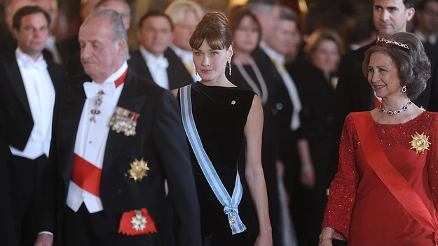 Carla Bruni

Modelka i piosenkarka Carla Bruni wywołała sensację, gdy wyszła za mąż za prezydenta Francji – Nicolasa Sakroziego w 2008 roku w Pałacu Elizejskim w Paryżu. Pierwszy raz w historii Republiki Francuskiej głowa państwa wzięła ślub podczas sprawowania urzędu. Co więcej Bruni była młodsza od ukochanego o 13 lat. Francuzi nie byli zachwyceni ani różnicą wieku między małżonkami, ani eksponowaniem życia prywatnego przez prezydenta. Nie można jednak nie zgodzić się z faktem, że Carla z klasą prezentowała kraj na ważnych wydarzeniach.

Podczas wizyty w Hiszpanii para prezydencka wzięła udział w królewskiej ceremonii. Carla zachwyciła gości prostą, ale efektywną kreacją z czarnego weluru. Związała włosy w zgrabny kok, a cały wizerunek wzbogaciła o wiszące kolczyki i szeroką bransoletkę, ozdobioną cyrkoniami. Klasyczna stylizacja przypominała styl sławnej aktorki, Audrey Hepburn.  
