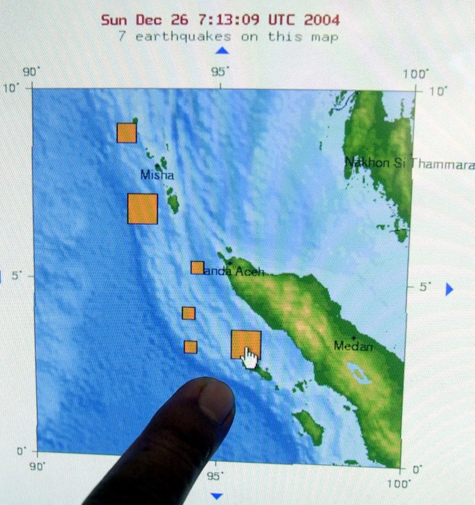 Urzędnik Biura Meteorologii i Geofizyki w Dżakarcie wskazuje na jeden z obszarów indonezyjskiej wyspy Sumatra najbardziej dotkniętych silnym trzęsieniem ziemi 26 grudnia 2004 r. 