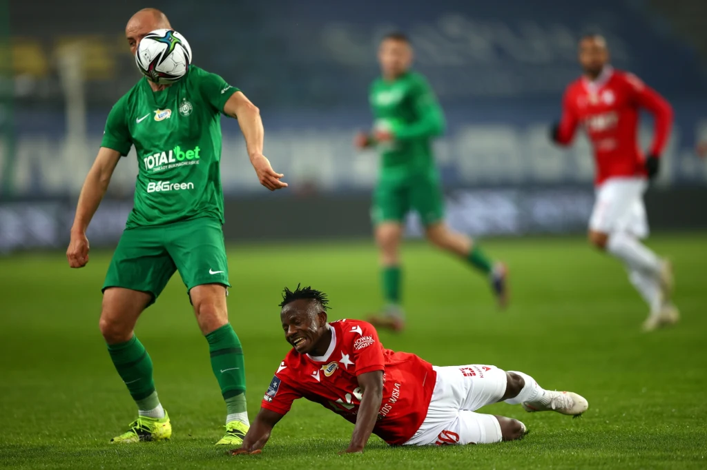 Zawodnik Wisły Kraków Yaw Yeboah (z prawej) i Łukasz Trałka z zespołu Warta Poznań