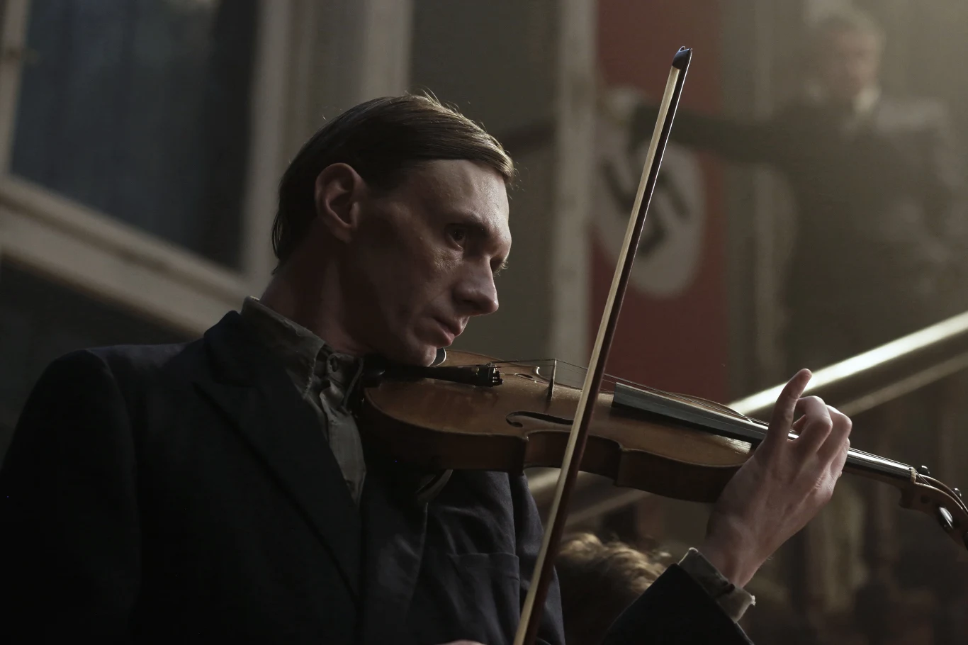 W czasie okupacji nie wiedzie mu się dobrze. Szansą na zarobek stają się wstępy w lokalu dla Niemców. Ci nie wyobrażają siebie jednak orkiestry bez skrzypka. Wówczas Cudak na koncerty wyprowadza z getta uzdolnionego Szymona Akerman, z którym przed wojną nie żył w zgodzie.
