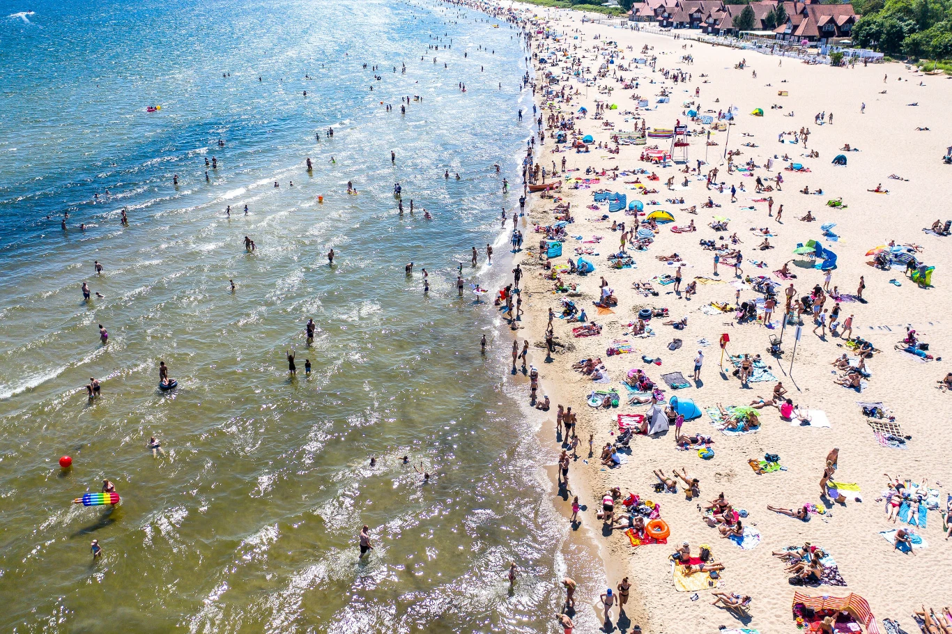 Przebywający w Sopocie turyści godzinami odpoczywają na plaży, ciesząc się krystalicznym powietrzem i relaksującym szumem fal Przebywający w Sopocie turyści godzinami odpoczywają na plaży, ciesząc się krystalicznym powietrzem i relaksującym szumem fal