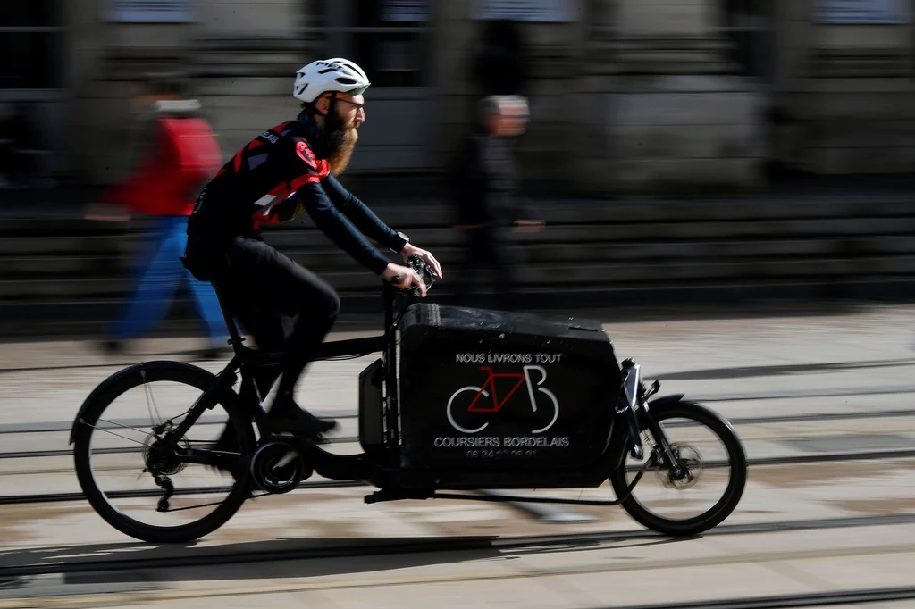 Kurier poruszający się rowerem towarowym we Francji w Bordeaux.
