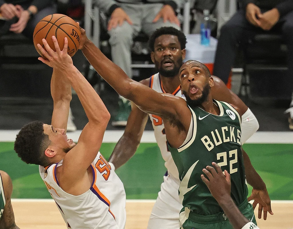 Khris Middleton (z prawej) blokuje próbę Devina Bookera