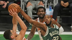 Khris Middleton (z prawej) blokuje próbę Devina Bookera