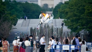 Ludzie robiący sobie zdjęcia przed zniczem olimpijskim w Tokio