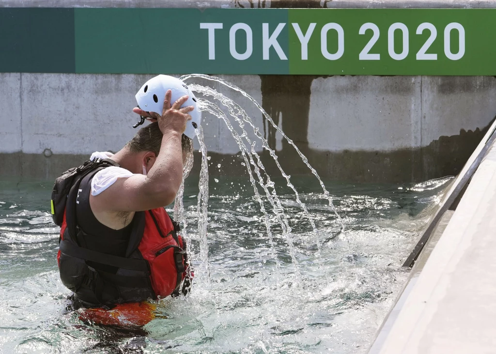 Ratownik wylewający sobie wodą na głowę podczas treningu olimpijskiego.
