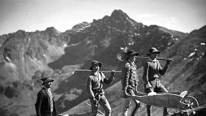 Budowa kolejki linowej z Kuźnic na Kasprowy Wierch. Górale transportują na drewnianych taczkach budulec potrzebny do budowy kolejki linowej