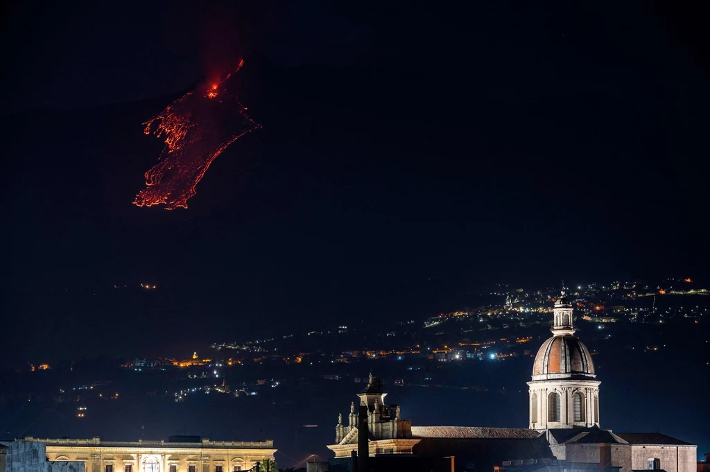 Erupcja Etny nocą, widać spływającą po górze lawę