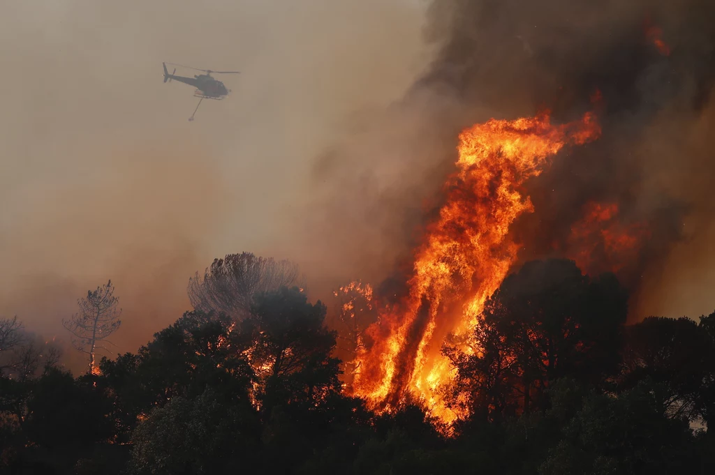Na zdjęciu: helikopter gaśniczy walczy z ogniem w okolicach wsi Cannet des Maures na południu Francji.