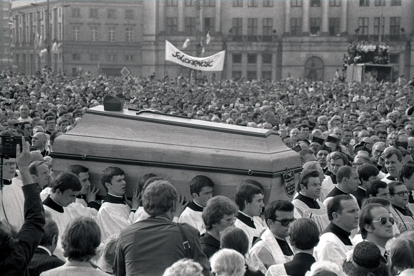 Plac Zwycięstwa (dziś Plac Piłsudskiego) w Warszawie. Tłum zgromadzony wokół trumny z ciałem kard. Stefana Wyszyńskiego, niesionej w kierunku ołtarza. W tle widać transparent "Solidarności". Plac Zwycięstwa (dziś Plac Piłsudskiego) w Warszawie. Tłum zgromadzony wokół trumny z ciałem kard. Stefana Wyszyńskiego, niesionej w kierunku ołtarza. W tle widać transparent "Solidarności".