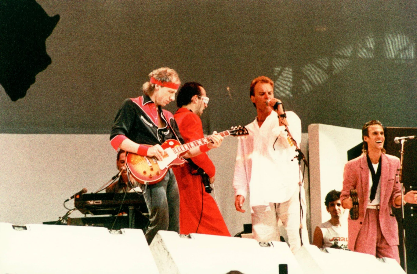 Sting jest współtwórcą wielkiego przeboju Dire Straits, "Money For Nothing" - to on śpiewa pierwsze słynne słowa "I want my MTV", które stały się kultowym zwrotem w USA. Na zdjęciu podczas występu na Live Aid w 1985 roku, wraz z Dire Straits.
