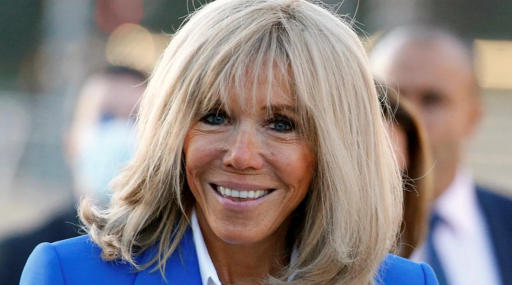 Brigitte Macron chętnie nosi białe, taliowane koszule. Jeżeli twoje są zbyt szerokie, jest na to sposób. Wystarczy dolny guzik zapiąć oczko wyżej i koszula będzie układała się idealnie