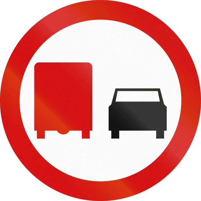 Znak zakazu B-26. Zakaz wyprzedzania przez samochody ciężarowe.