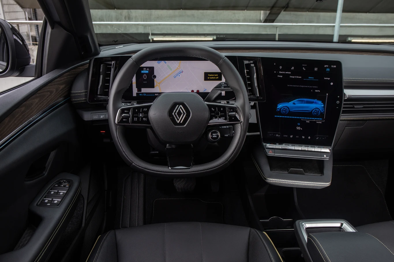 Samo wnętrze jest, jak na elektryka przystało, całkiem minimalistyczne, ale nie do tego stopnia, aby utrudniać kierowcy obsługę. Ma on przed sobą ekran o przekątnej 12,3 cala, pełniący rolę wskaźników, który łączy się wizualnie z wyświetlaczem multimediów. Standardowo ma on 9 cali, a za dopłatą 12, lecz sprawia wrażenie większego, ponieważ jego proporcjom blisko do kwadratu. Co ważne, umieszczono pod nim rząd fizycznych przycisków do obsługi klimatyzacji, co w dzisiejszych czasach staje się coraz bardziej docenianym rozwiązaniem. Poniżej umieszczono występ z półką na smartfona, mającą indukcyjną ładowarkę. 