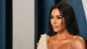 Kim Kardashian w obcisłej sukni z głębokim dekoltem. Zdobią ją religijne symbole