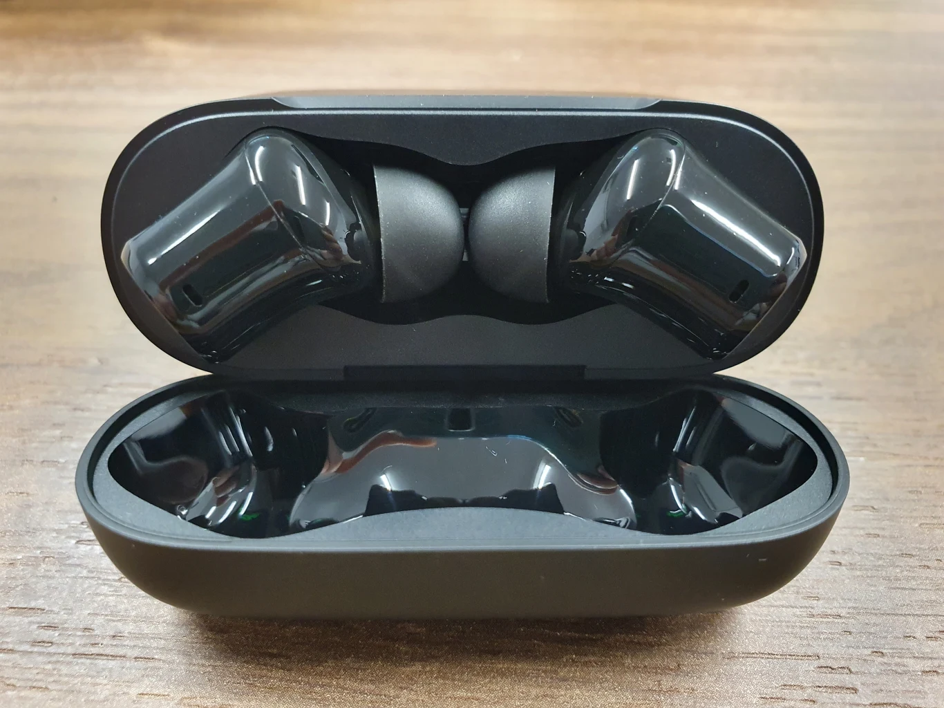 Pod wiekiem, w środku znajduje się wyprofilowane miejsce na słuchawki, z przodu umiejscowiono diodę wskazującą poziom naładowania. W dolnej części zlokalizowano port USB-C. 