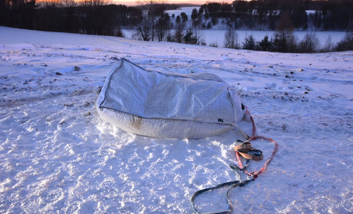 Dwie kobiety i dziecko siedziały na worku ciągniętym za samochodem