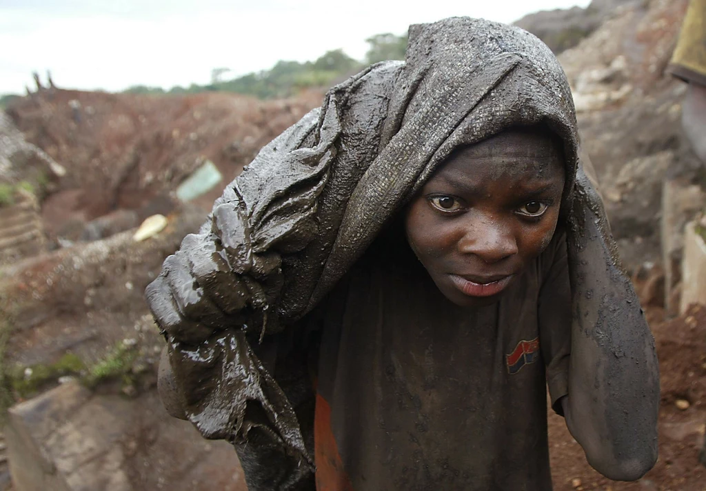 Młody człowiek niosący worek z rudą kobaltu w Demokratycznej Republice Konga. 