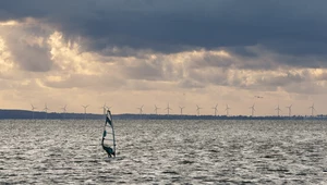 Windsurfer na tle farmy wiatrowej w Swarzewie.