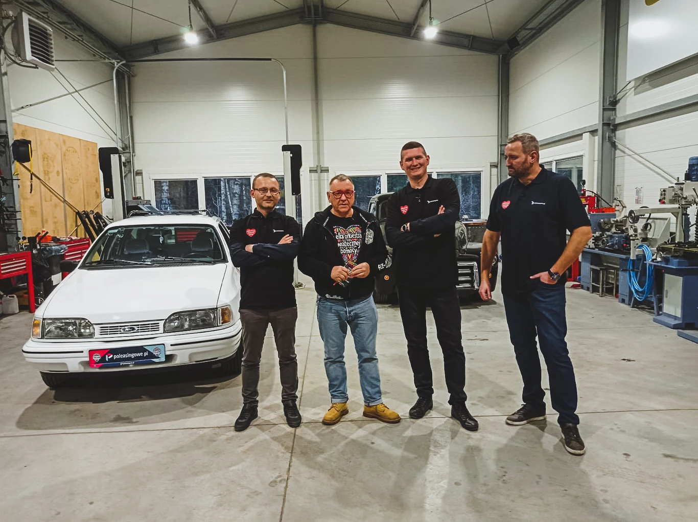 Przemysław Wałasz, Jurek Owsiak, Artur Kopania i Adam Klimek w warsztacie, w którym została odnowiona Sierra.