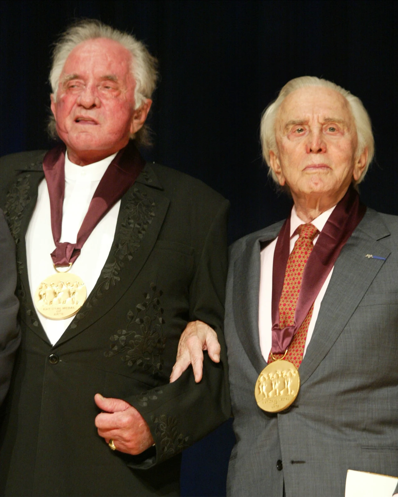Legendarny Johnny Cash zmarł 12 września 2003 roku, zaledwie 4 miesiące po swojej żonie. Jeszcze w lipcu tegoż roku zagrał ostatni koncert, którym oddał jej hołd. "Duch June Carter przyćmiewa mnie dziś swą miłością, którą mnie obdarzała i miłością, którą obdarzałem ją ja. Łączymy się gdzieś pomiędzy tym miejscem, a Niebem. Przyjechała na krótką wizytę, jak sądzę, z Nieba, aby odwiedzić mnie dziś wieczorem, aby dodać mi odwagi i inspiracji, tak jak zawsze. Nigdy nie przestała być dla mnie ucieleśnieniem odwagi i inspiracji. Dziękuję Bogu za June Carter. Kocham ją całym sercem" - przeczytał wówczas uczestnikom koncertu. Mówiło się wówczas, że mąż i żona znów są razem, szczęśliwi. Na zdjęciu Johnny Cash i Kirk Douglas w 2002 roku. Obaj zostali wówczas odznaczeni przez prezydenta George'a W. Busha medalem za zasługi dla amerykańskiej kultury.