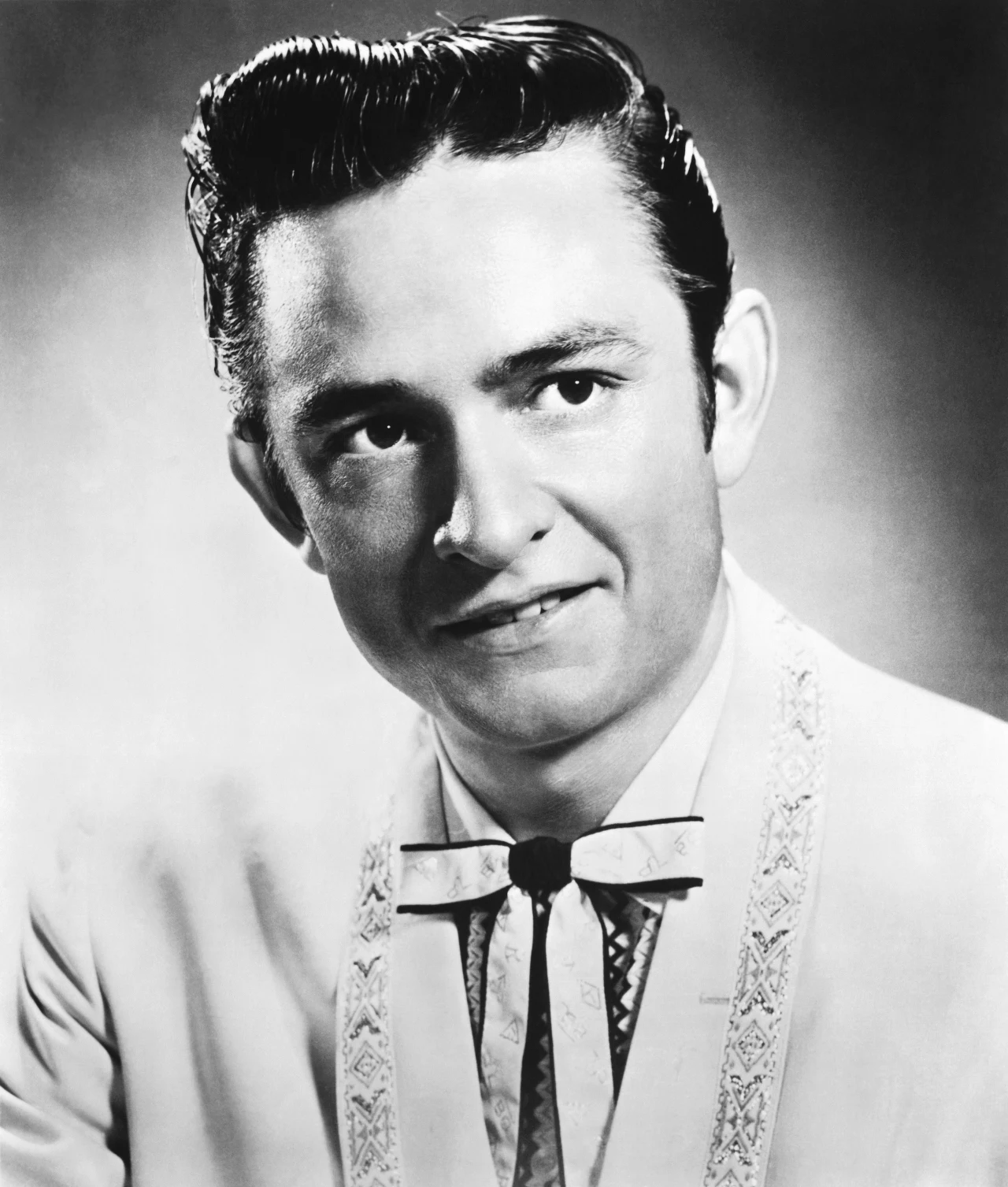 Johnny Cash przyszedł na świat 23 lutego 1932 roku. Wywodził się z niezbyt bogatej rodziny, a już jako pięciolatek pracował na polu bawełny wraz z rodzicami. Jak sam później mówił, to właśnie ten okres w jego wczesnym życiu wpłynął na zainteresowanie losem biednych, a także bardzo mocne im współczucie. Cash miał sześcioro rodzeństwa, a w 1944 roku jego brat zginął w tragicznym wypadku - został przecięty przez piłę podczas pracy. Pracował po to, by poprawić byt rodzinie Cashów, czego ponoć do końca życia wokalista nie mógł sobie wybaczyć. Johnny Cash w 1956 roku.