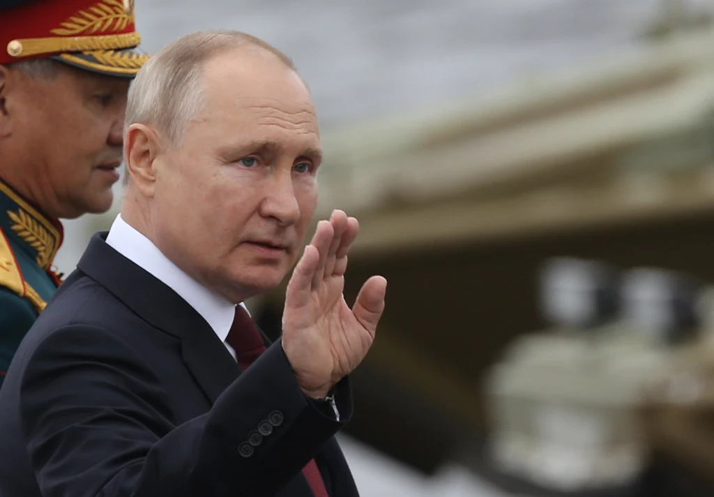 Władimir Putin swobodnie wymachuje lewą ręką, ale prawą pozostawia nieruchomą lub wykorzystuje ją tylko w celu powitania