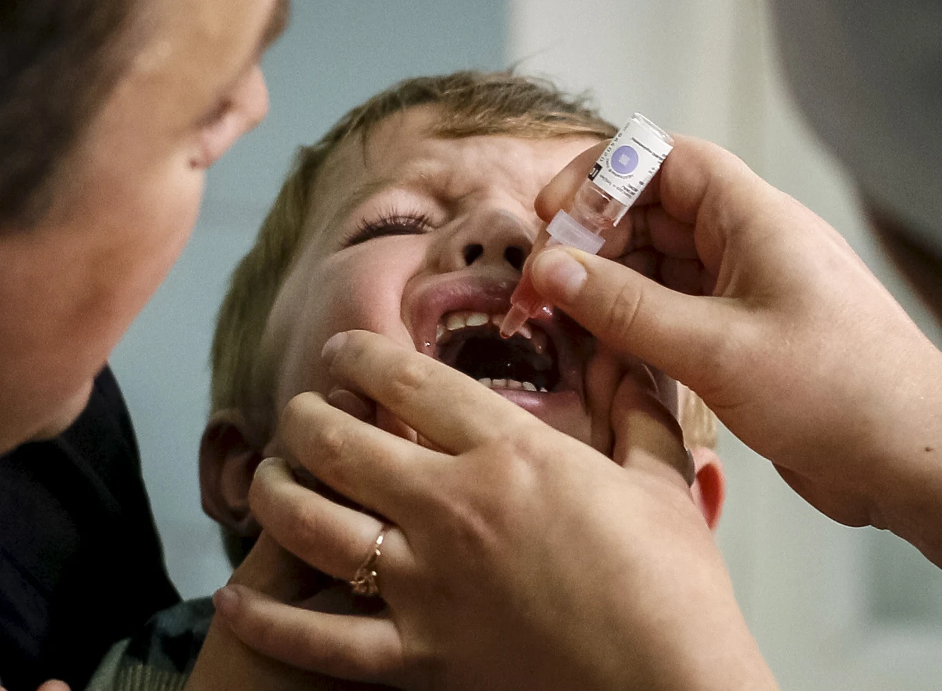 Na zdj. ukraiński chłopiec przyjmujący doustną szczepionkę przeciw polio (2015 rok) 