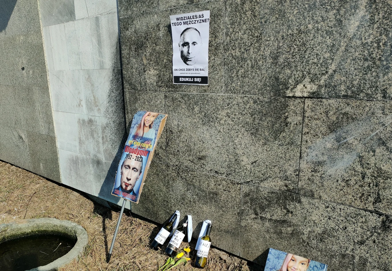 Protestujący po wybuchu wojny w Ukrainie zostawili plakat i transparent przy murze wokół dawnego rosyjskiego osiedla