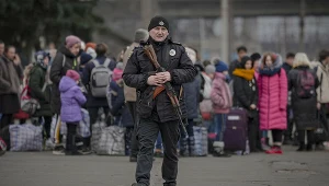Ukraiński policjant pilnujący ludzi czekających na ewakuację z Kijowa