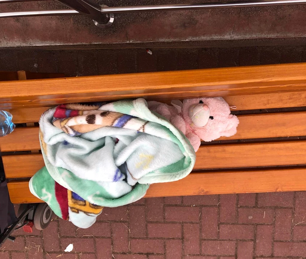 Miś przykryty kocem przez dziecko, które czeka w punkcie recepcyjnym