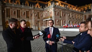 Premier Mateusz Morawiecki (C) podczas konferencji prasowej przed Pałacem Wersalskim