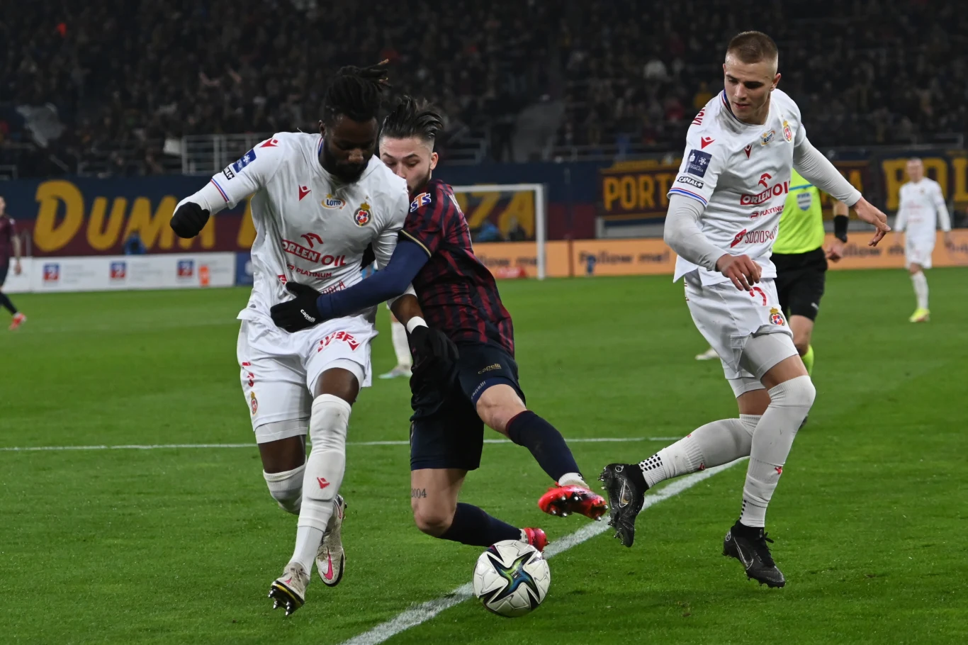 Piłkarz Pogoni Szczecin Sebastian Kowalczyk (C) oraz Konrad Gruszkowski (P) i Joseph Colley (L) z Wisły Kraków podczas meczu Ekstraklasy Piłkarz Pogoni Szczecin Sebastian Kowalczyk (C) oraz Konrad Gruszkowski (P) i Joseph Colley (L) z Wisły Kraków podczas meczu Ekstraklasy