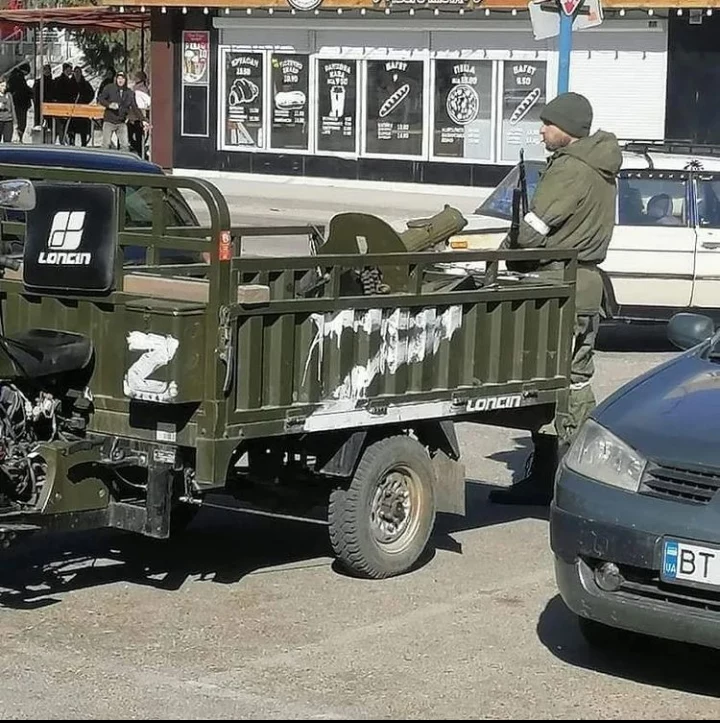 Rosyjski żołnierz przy karabinie maxim zamontowanym na chińskim tuk-tuku