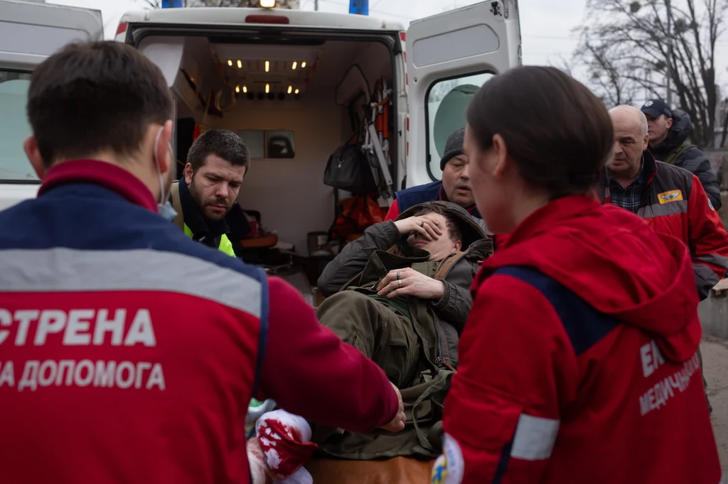 Ukraińscy ratownicy pomagają rannym po ostrzale miejscowości Irpień