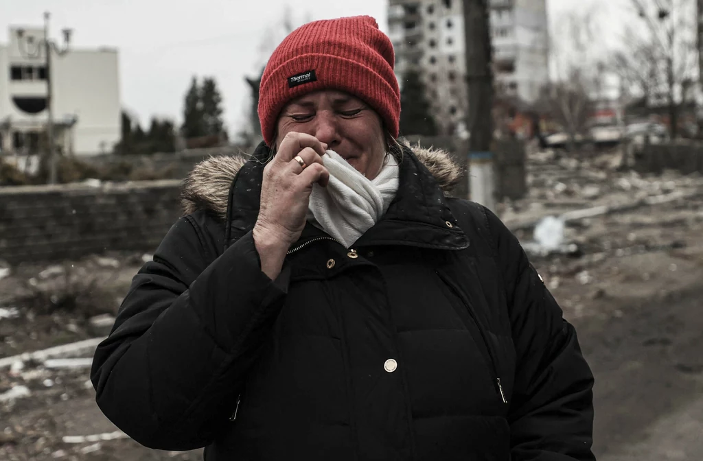 Mieszkanka miasta Borodianka płacząca na tle zrujnowanego przez Rosjan miasta Mieszkanka miasta Borodianka płacząca na tle zrujnowanego przez Rosjan miasta