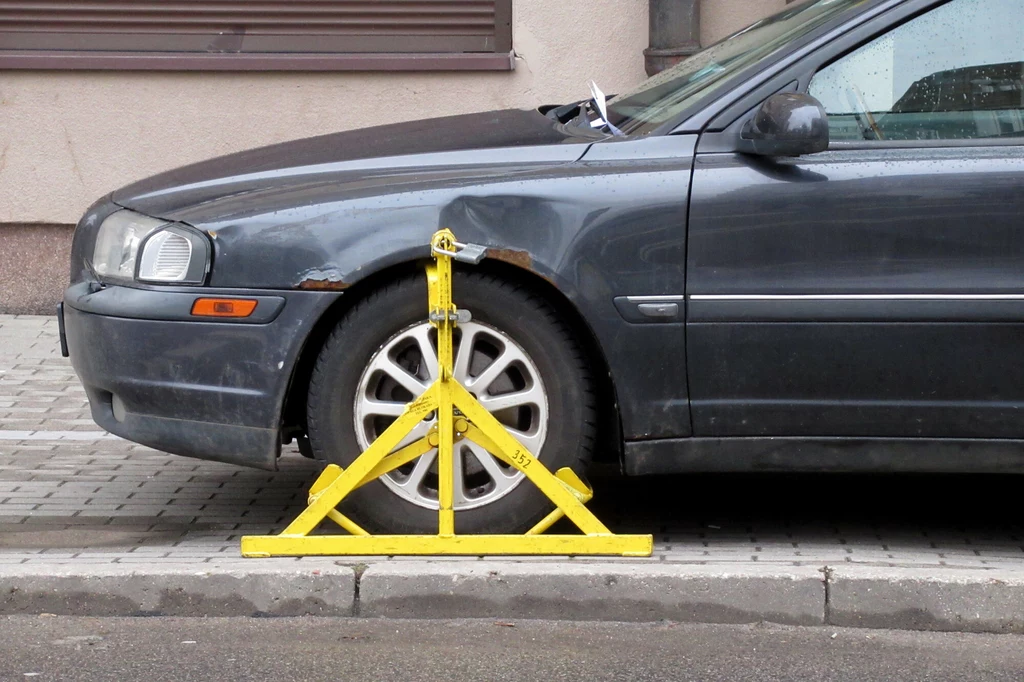 Za złe parkowanie grozi nie tylko mandat. Na koło może też być nałożona blokada. Auto można też odholować.