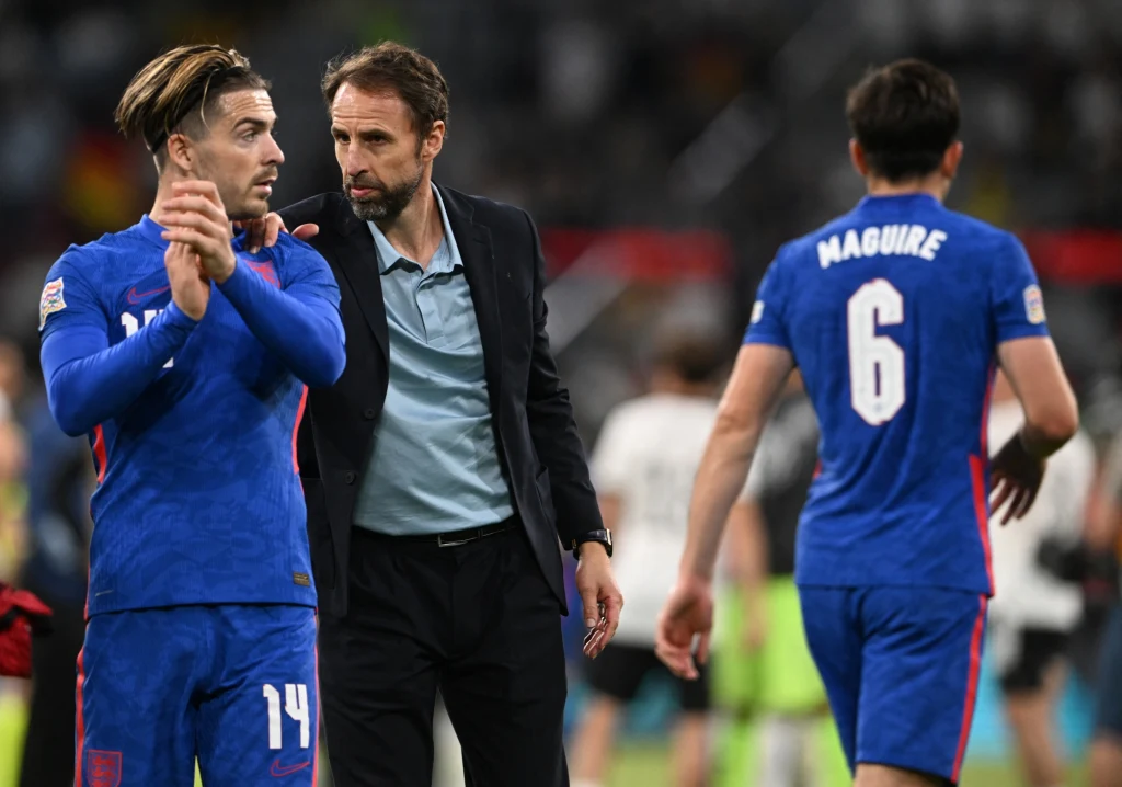 England's midfielder Jack Grealish (L) and England's head coach Gareth Southgate (C) react after the UEFA Nations League football match Germany v England in Munich, southern Germany on June 7, 2022. CHRISTOF STACHE / AFP