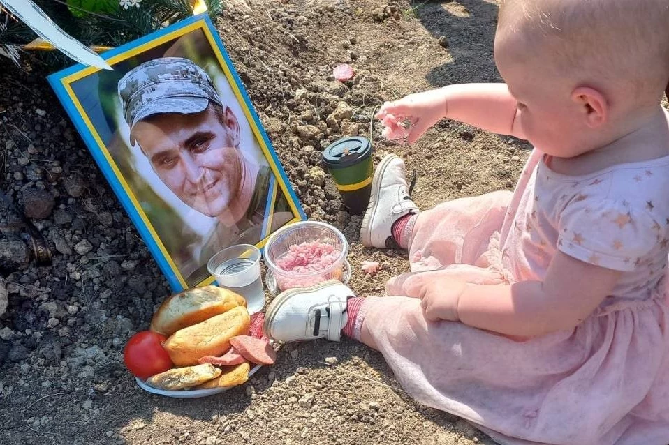 Dziewczynka obchodzi swoje urodziny przy grobie taty