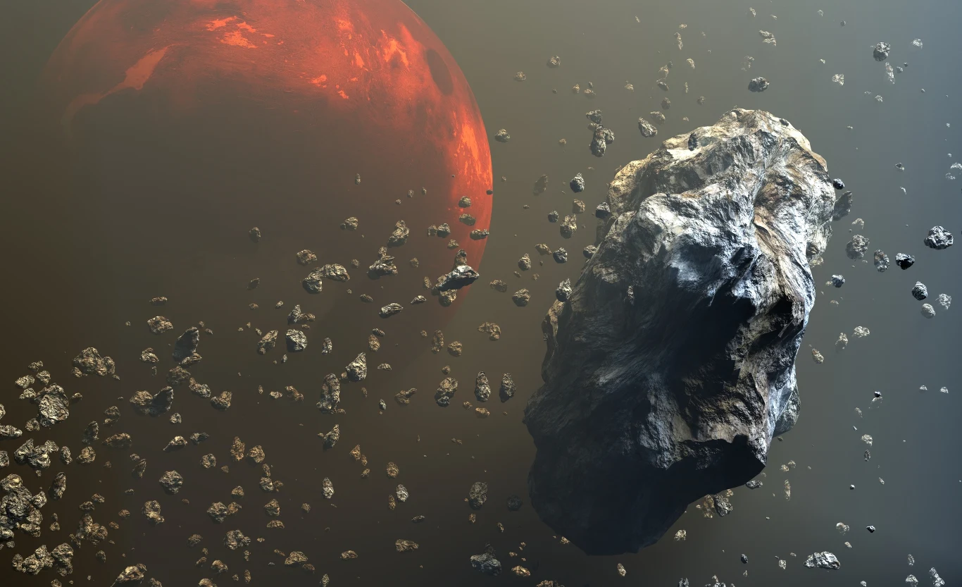 Badania marsjańskiego meteorytu NWA 13441 przyniosły zaskakujące rezultaty. Fragmenty NWA 13441 unoszące się w kosmosie z mniejszymi odłamkami na tle Marsa w czerwonej poświacie.