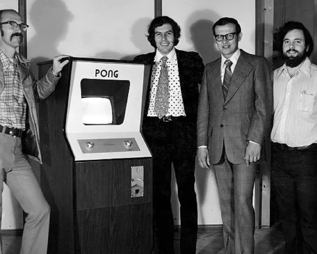 Od lewej: Ted Dabney, automat PONG, Noal Bushnell, Fred Marincic, Al Alcorn. źródło: wikipedia